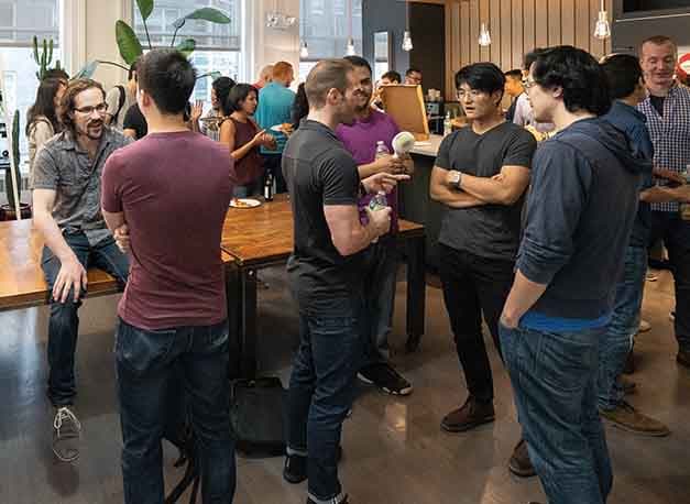 Room full of people chatting at an Operation Code meetup in New York City.